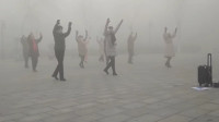 在雾霾中坚持跳广场舞 笑称用生命在跳舞