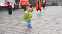 公园里两岁多的小孩和大人一起跳广场舞