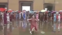 60岁大妈在雨中跳广场舞，舞姿优美，引路人围观！